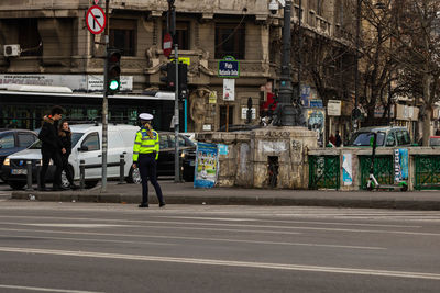 People on road against buildings in city