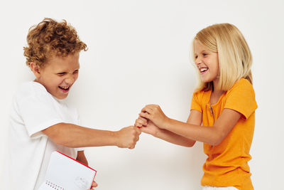 Portrait of smiling mother and daughter against white background