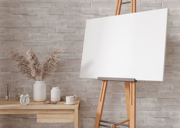 Empty horizontal canvas on wooden easel in modern and cozy room. canvas mock up, interior