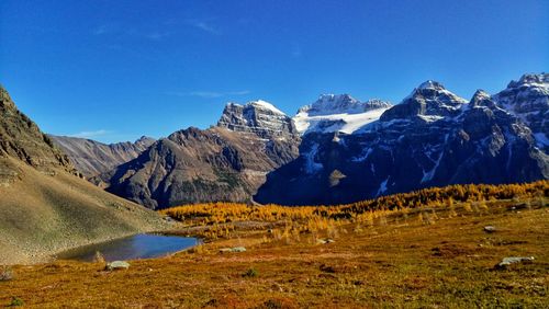 Scenic view of snowcapped mountains against clear blue sky