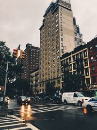 Cars on road in city against sky