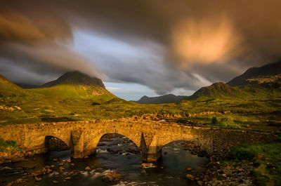 Arch bridge over lake against sky