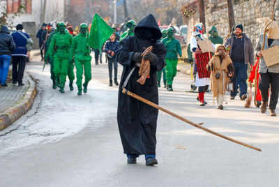 Group of people walking on road in city