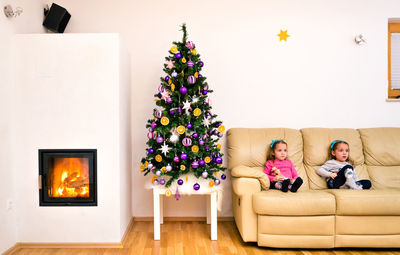 Girl on christmas tree at home