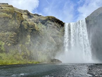 Scenic view of waterfall against sky