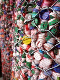 Close-up of plastic bottle caps in fence