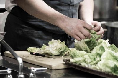 Midsection of man preparing food in kitchen