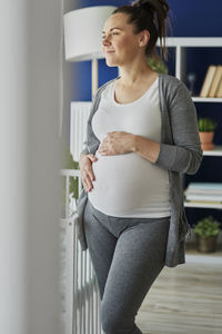 Mid adult woman standing against wall