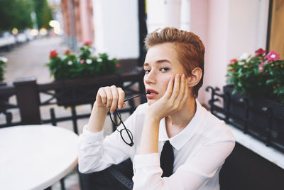 Portrait of young woman sitting on table