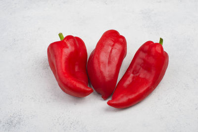 High angle view of red chili peppers on white background