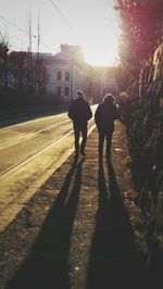 Men walking on silhouette trees against sky