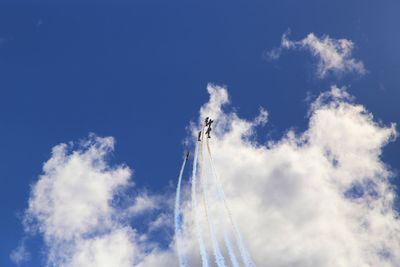 Low angle view of airplane flying against blue sky