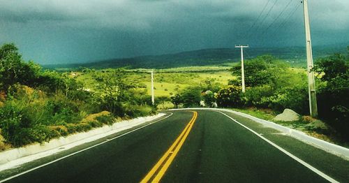 Road amidst trees against sky