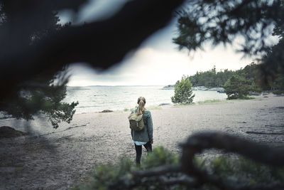 Rear view of wonderlust woman standing at lakeshore