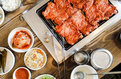 High angle view of grilled meat with salad on table