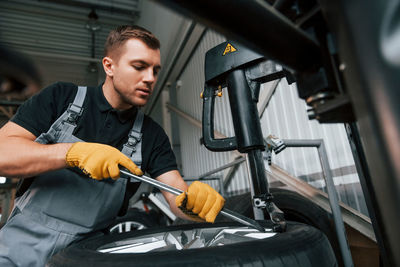 Employee at work. man in uniform is in the auto service.