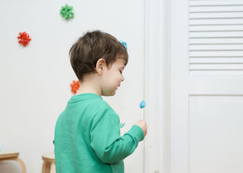 Cute baby boy enjoying a lollipop at home