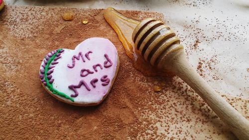 High angle view of cookie and honey dipper on table