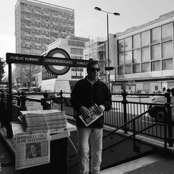 Man standing on street against buildings in city