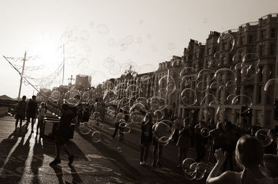 People in front of buildings against clear sky