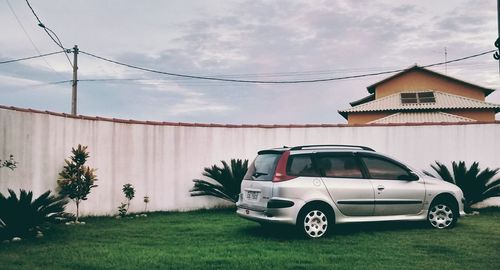 Cars on house by building against sky