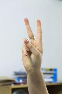 Cropped hand gesturing peace sign