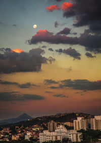 Aerial view of illuminated buildings in city at sunset