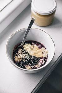 High angle view of breakfast, porridge with blueberries, served on table, healthy eating. 