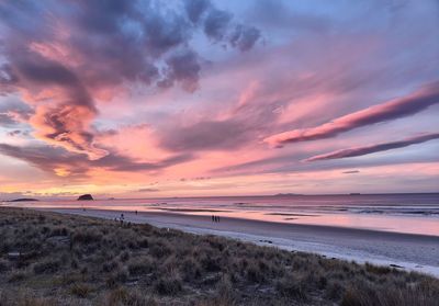 Scenic view of beach against romantic sky at sunset