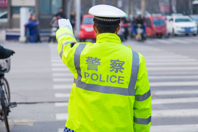 Rear view of traffic cop standing on street