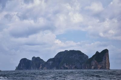 Rock formations by sea against sky