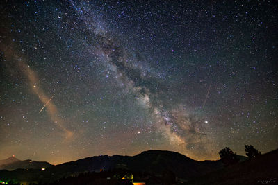 Scenic view of mountains against star field at night