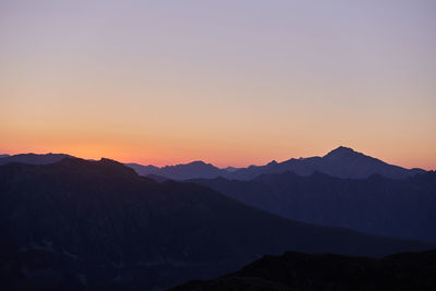 Scenic view of silhouette mountains against clear sky during sunset