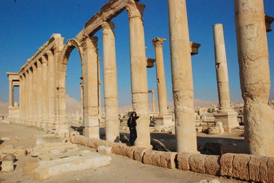 Mid distance view of woman standing by column at historic site