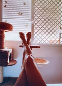 Low section of woman relaxing on window