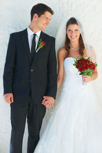 Portrait of smiling couple standing against white background