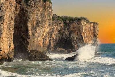 Waves crashing against rock on the shore.fierce,tumbling wave view, jumping spray scene on vast sea.