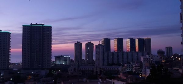 View of illuminated buildings against sky during sunset