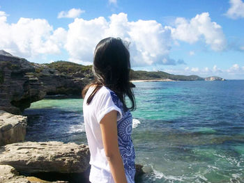 Rear view of man looking at sea against sky