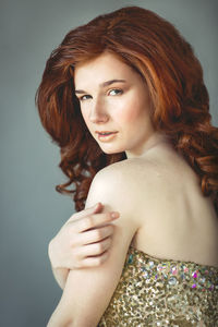 Portrait of a beautiful young woman against gray background