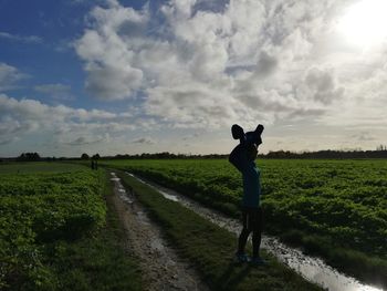 Woman standing on field against sky