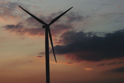 Low angle view of silhouette wind turbine against sky during sunset