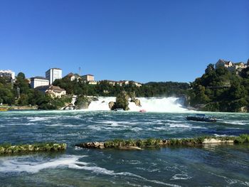 Scenic view of river against clear blue sky