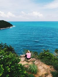 Rear view of man looking at sea against sky