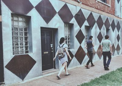 Rear view of woman standing against built structure