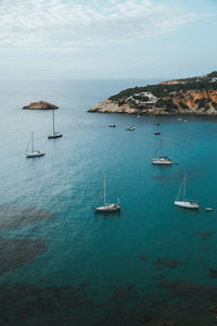 Sailboats in sea against sky