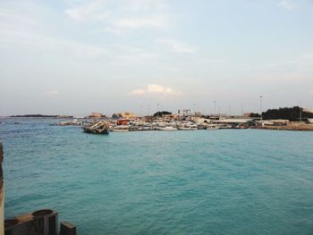 Scenic view of sea by buildings against sky