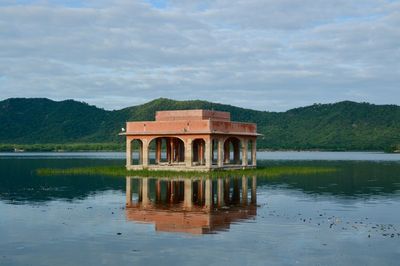 Built structure by lake against sky