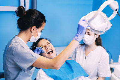 Dentists examining woman in clinic