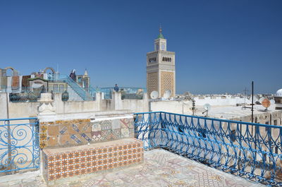 Buildings in city against clear blue sky